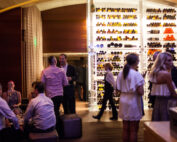 Guests mingling in front of wine case